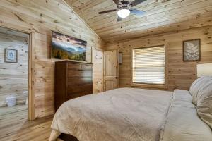 een slaapkamer met een bed en een plafondventilator bij Misty Cove Cabin in Cosby