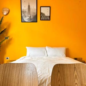 a bedroom with an orange wall with a bed at 虎尾慢遊 in Huwei
