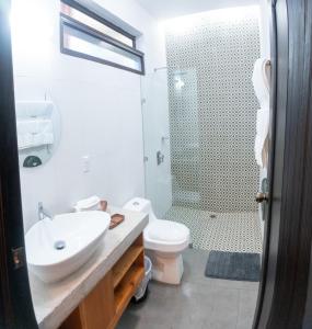 a bathroom with a sink and a toilet and a shower at Hotel Kopal in Lanquín