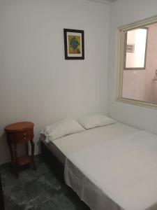 1 dormitorio con 2 camas, espejo y mesa en Apto 3 alcobas, Tercer piso Norte de Cali, en Cali