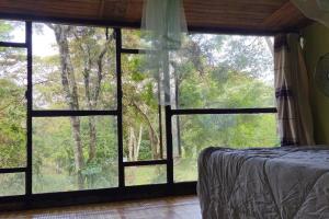 a bedroom with a bed and a large window at Nairobi Karen Tree House in Nairobi