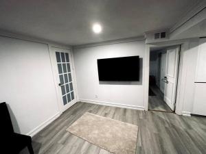 a living room with a flat screen tv on the wall at Fully furnished unit in Northyork! in Toronto
