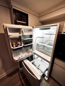 an empty refrigerator with its door open in a kitchen at Fully furnished unit in Northyork! in Toronto
