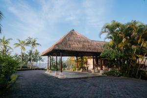 un pavillon avec des palmiers en face d'un bâtiment dans l'établissement Puri Wulandari A Boutique Resort & Spa - CHSE Certified, à Ubud