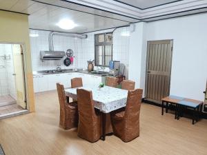 a kitchen with a table and chairs in a room at Bokelai B&B in Ren'ai