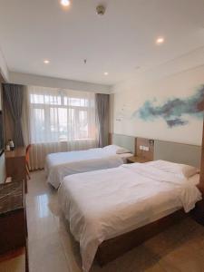 um quarto de hotel com duas camas e um quadro na parede em Biling Hotel em Fangshan