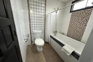 uma casa de banho branca com um WC e uma banheira em Chiangrai Grand Room Hotel em Chiang Rai