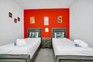zwei Betten in einem Zimmer mit einer orangefarbenen Wand in der Unterkunft Luxury Home at Sonoma 9 En-suites SON102 in Kissimmee + 64 Fotos