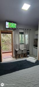 a bedroom with a bed with a television and a table at La Bella Luna Suítes in Alto Paraíso de Goiás
