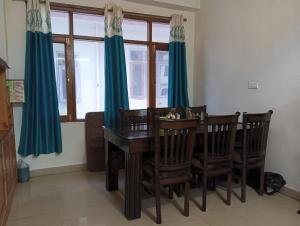 a dining room with a wooden table and chairs at ASTON HOME STAY in Chhota Simla