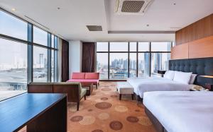 um quarto de hotel com duas camas e uma grande janela em Orakai Songdo Park Hotel em Incheon