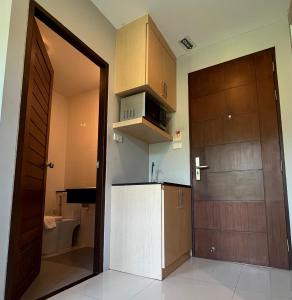 a small kitchen with a door and a sink at Hidayah Condotel,Ao-nang, Krabi in Ban Khlong Haeng