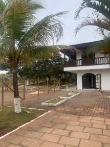 a building with a palm tree in front of it at Hotel Pousada Flat Royal Suíte Stander 2 camas box in Itapecerica +23 photos