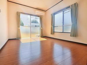 an empty room with a hardwood floor and two windows at Lit 天草 in Amakusa