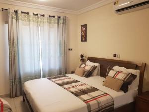 a bedroom with a large bed with pillows at FOKUZZY LODGE in Accra +59 photos