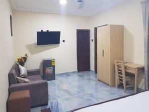 a living room with a couch and a table at FOKUZZY LODGE in Accra