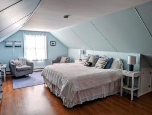 a bedroom with a large bed and a chair at Beachy Watering Cove Cottage NEW in Prospect Harbor