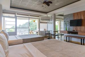 1 dormitorio con 2 camas y TV de pantalla plana en Tanawin BnB en Orani