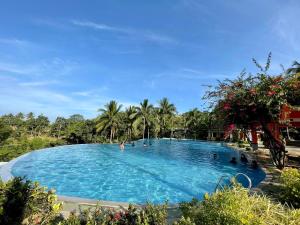 a pool at a resort with people in it at Tanawin BnB in Orani +13 photos