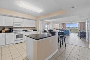 a large kitchen with white cabinets and a counter top at Yacht Club Villas #1-701 condo in Myrtle Beach