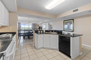 a kitchen with white cabinets and black counter tops at Yacht Club Villas #1-701 condo in Myrtle Beach