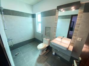 La salle de bains est pourvue d'un lavabo, de toilettes et d'un miroir. dans l'établissement Furnished luxury Vacation Apartment in DHA Phase 8, à Karachi