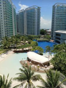 a large swimming pool with palm trees and buildings at SM Bicutan Condominium in Manila