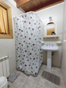 een badkamer met een douchegordijn en een wastafel bij Cabañas Carelmapu in Bariloche +7 foto's