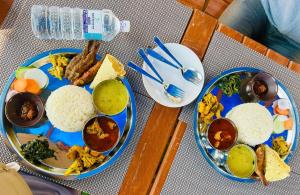 Hotel Kavya Inn في بهاراتبور: طاولة عليها طبقين من الطعام