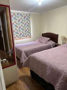 a hotel room with two beds and a window at Casa Ann in Osorno