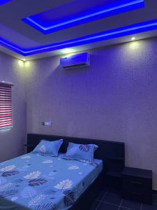 a room with a bed with a blue light at LGH (Luxury Guest House) Résidence in Lomé
