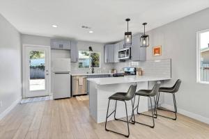 a kitchen with a white counter and chairs in it at San Diego Heights - Urban Legend in San Diego