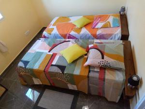 a bed with a colorful comforter and pillows at Villa LANDREVA in Anse-Bertrand +6 photos