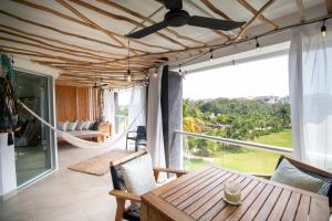 Habitación con mesa, sillas y ventana grande. en Luxury Beachfront Resort at MAREAZUL en Playa del Carmen