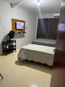 1 dormitorio con 1 cama y TV de pantalla plana en Lindo apartamento coração de Picos en Picos