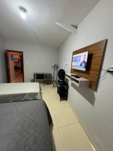 um quarto com uma cama e uma televisão de ecrã plano em Lindo apartamento coração de Picos em Picos