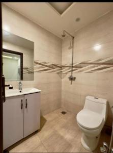 y baño con aseo y lavamanos. en 1 bed apartment available in Al nadd, en Sharjah