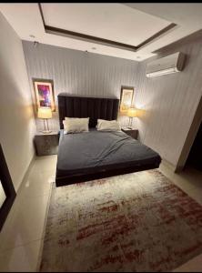 1 dormitorio con 1 cama grande y 1 alfombra en 1 bed apartment available in Al nadd, en Sharjah