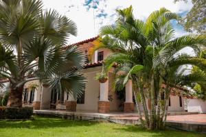 une maison avec des palmiers devant elle dans l'établissement Casa Isidra, à Rivera