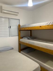 two bunk beds in a room with a window at Apê 06 Maresias in Maresias