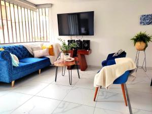sala de estar con sofá azul y TV en Casa Cielo en Paipa Centro, en Paipa
