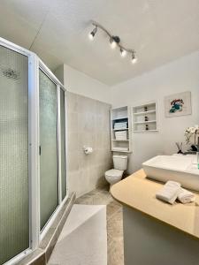y baño con ducha, lavabo y aseo. en Tiaki Guesthouse - Cozy Modern Studio - 5min drive from the beach and Punaauia center, en Punaauia