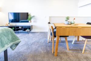 a dining room with a table and a couch at City Living: Upper Studio Haven on Wilmer in Christchurch