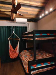 a room with two bunk beds and a ceiling fan at SLEEPY MOUNTAIN in Karatsu