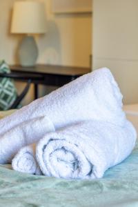 a white towel sitting on top of a bed at City Living: Upper Studio Haven on Wilmer in Christchurch