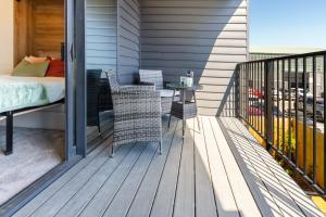 a porch with a bed and a table on a balcony at City Living: Upper Studio Haven on Wilmer in Christchurch