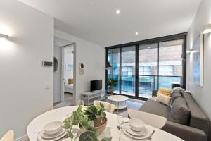 a living room with a couch and a table at A Chic & Comfy 2BR Apt Near Federation Square in Melbourne
