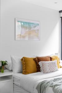 a bed with a bunch of pillows on it at A Chic & Comfy 2BR Apt Near Federation Square in Melbourne