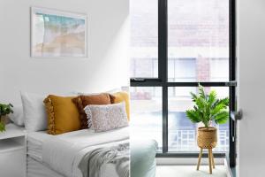a living room with a bed and a window at A Chic & Comfy 2BR Apt Near Federation Square in Melbourne
