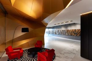 a lobby with red chairs and a ceiling at A Chic & Comfy 2BR Apt Near Federation Square in Melbourne